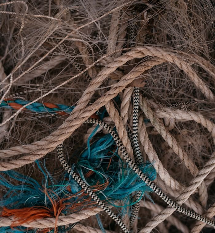 Artistic close-up of tangled ropes and strings in various colors and textures.